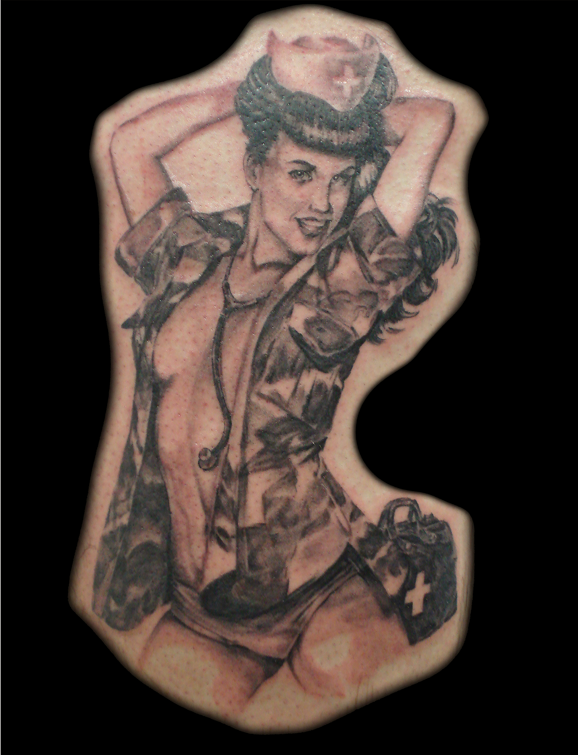 Bettie Paige pinup (pin up)  tattoo, done in realistic black and grey, She is a nurse with an open cammo blouse.