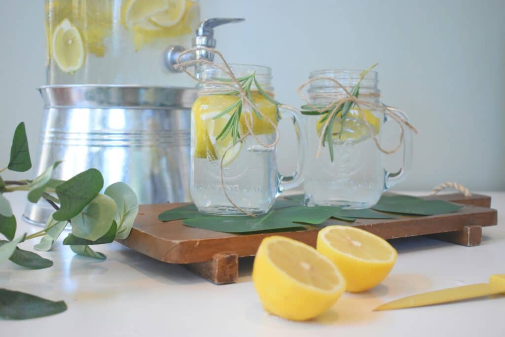 Image shows a pitcher of water with lemon in order to prepare for tattoo day - stay hydrated!